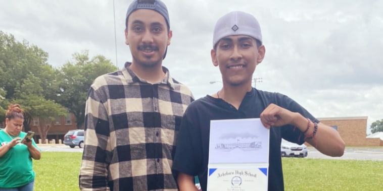 Asheboro High School senior Ever Lopez holds up his diploma