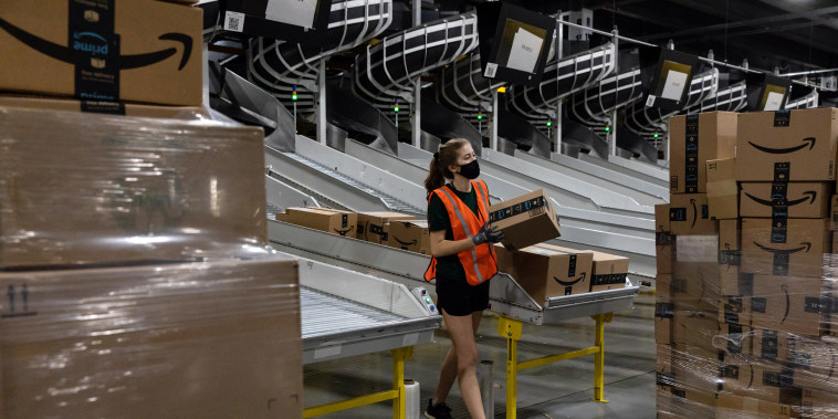 Image: A worker loads boxes onto a pallet at an Amazon fulfillment center in Raleigh, N.C., on  June 21, 2021.