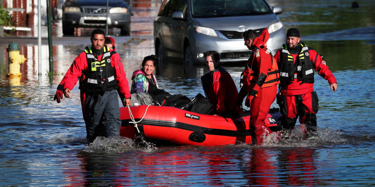 First responders pull local residents in a boat as they perform rescues of people trapped by floodwaters after the remnants of Tropical Storm Ida brought drenching rain, flash floods and tornadoes to parts of the northeast in Mamaroneck, N.Y., on Sept. 2, 2021.