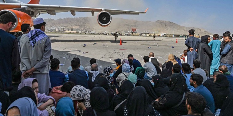 Afghans wait to leave the airport in Kabul on Aug. 16, 2021.