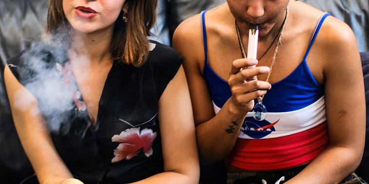 Two women smoke cannabis vape pens at a party in Los Angeles on June 8, 2019