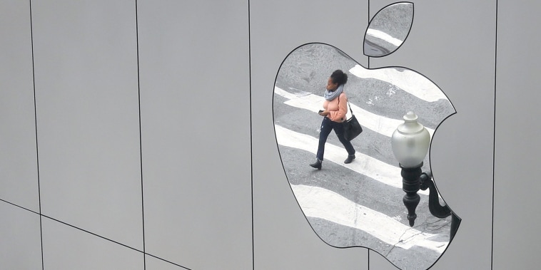 Image: A woman is reflected in a Apple store logo in San Francisco