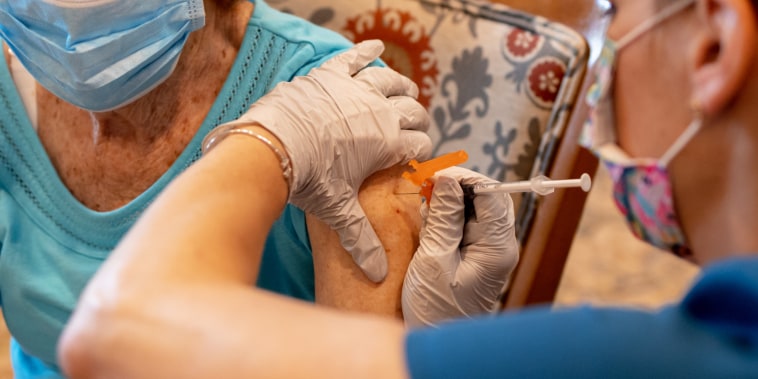 A health care worker administers a third dose of the Pfizer-BioNTech Covid-19 vaccine at a senior living facility in Worcester, Pa., on Aug. 25, 2021.