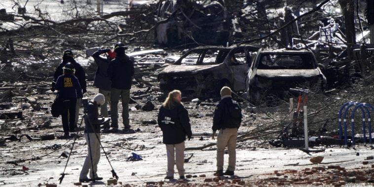 Investigators work near the site of an explosion on 2nd Avenue that occurred the day before in Nashville, Tenn., on Dec. 26, 2020.