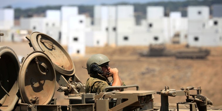 An Israeli soldier rides an armoured personnel carrier (APC) as it manoeuvres during in a drill at an urban warfare training base in the Israeli-controlled Golan Heights near the Israel-Syria frontier
