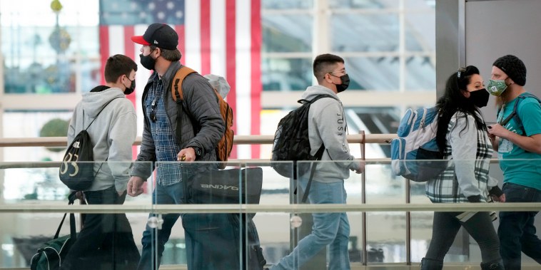 Travellers cross a bridge in the terminal of Denver International Airport on Dec. 24, 2021.