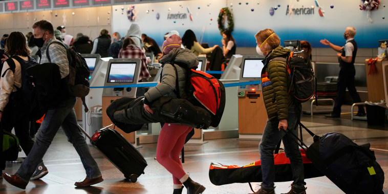 Los viajeros hacen fila en el counter de American Airlines en el Aeropuerto Internacional de Denver, el domingo 26 de diciembre de 2021.