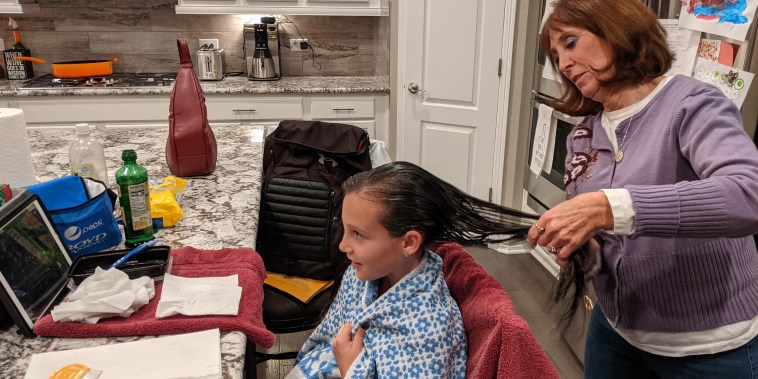 Linda Holmes, exterminadora de piojos profesional, peina el cabello de Huntley Marker, de 8 años, una noche de fines de octubre en la casa de la niña en Parker, Colorado. El negocio ha vuelto a subir para Holmes, después de una pausa por la pandemia.