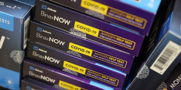 Image: Packages of Abbott Laboratories' BinaxNOW Covid-19 Antigen Self Test are stacked on a shelf in a store in N.Y., on Nov. 12, 2021.