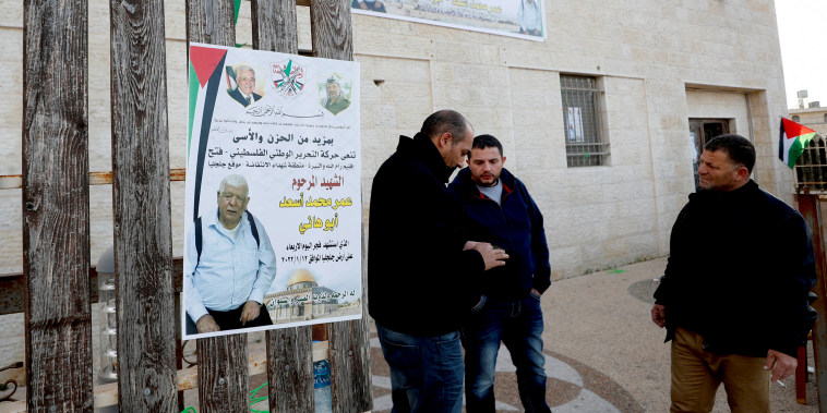 Image: Men stand next to a poster of Palestinian Omar Abdalmajeed As'ad, 80, in Jiljilya village in the Israeli-occupied West Bank