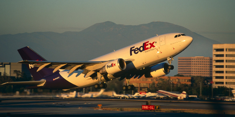 A FedEx freighter takes off at dusk.