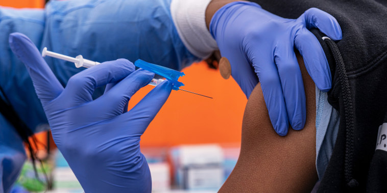 A healthcare worker administers a Pfizer-BioNTech Covid-19 vaccination in San Francisco on Jan. 10, 2022.