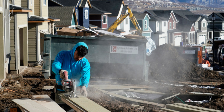 Image: A worker prepares siding to install on a single family home under construction in Lehi, Utah, on Jan. 7, 2022.
