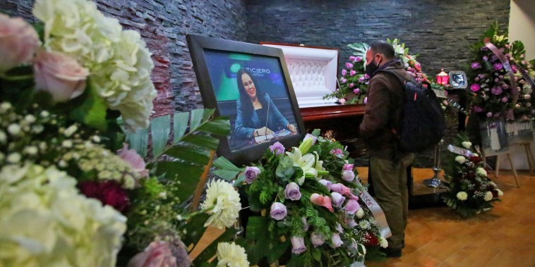 Image: A journalist looks on near the coffin of Mexican journalist Lourdes Maldonado during her wake in Tijuana