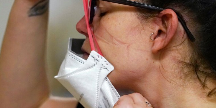 Una enfermera se coloca una mascarilla N95 nueva, después de tratar a un paciente con COVID-19 en el centro médico de Harborview, Seattle