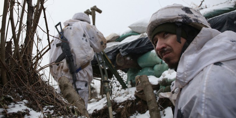 Agentes de las Fuerzas Militares de Ucrania se paran en una trinchera en el frente con los separatistas respaldados por Rusia cerca de la aldea de Verkhnetoretske, en la región de Donetsk, el 18 de enero de 2022.