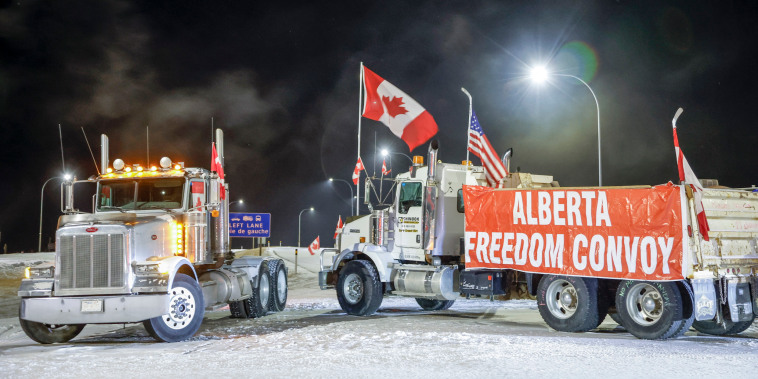 A truck convoy blocks the highway at the U.S. border crossing as demonstrators protesting against COVID-19 vaccine mandates gather in Coutts, Alberta, on Feb. 1, 2022.