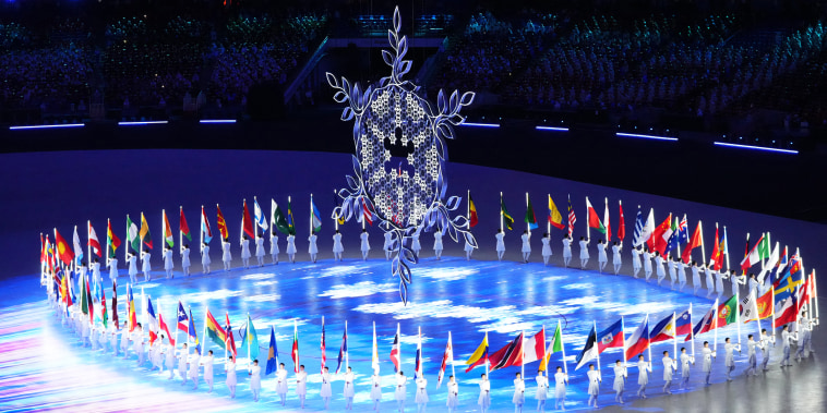 People hold national flags during the closing ceremony at the 2022 Beijing Winter Olympics on Nov. 20, 2022.