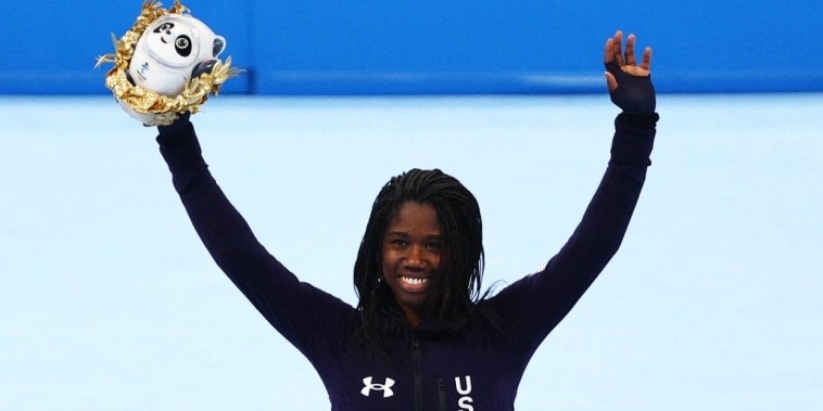 Gold medalist Erin Jackson celebrates on the podium during the flower ceremony on Feb. 13, 2022.
