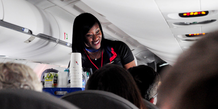 An American Airlines flight attendant serves drinks to passengers after departing from Dallas/Fort Worth International Airport in Texas on Oct. 3, 2017.
