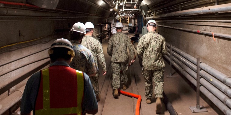 Rear Adm. John Korka, center, leads Navy and civilian water quality recovery experts through the tunnels of the Red Hill Bulk Fuel Storage Facility, near Pearl Harbor, Hawaii, on Dec. 23, 2021.