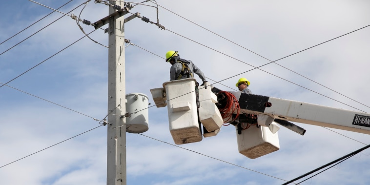 Workers fix power lines after the earthquake in Guayanilla