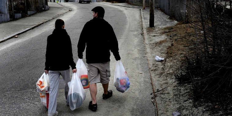 WOONSOCKET, RI - MARCH 01: (L) Amanda Aubin and Cody Allison carry $70.00 worth of groceries to their apartment about one-half mile away. They had money left over on their food stamp card but this amount of food was all that they could carry on foot. Some of the items purchased were for their 4 year-old daughter who was having a birthday party the next day. Many families and individuals in Woonsocket, Rhode Island are needy and take part in the SNAP (food stamps) program.