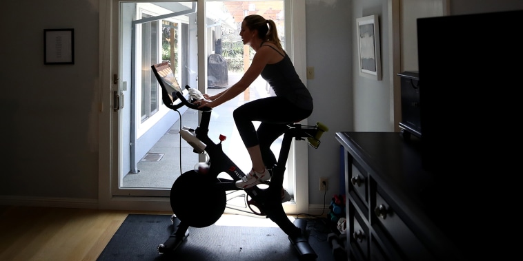 Image: Jen Van Santvoord rides her Peloton exercise bike at home in San Anselmo, Calif., on April 7, 2020.
