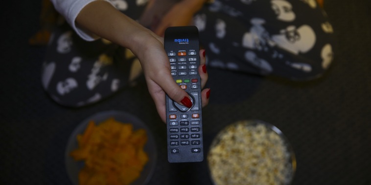 A woman holds a remote controller while eating snacks in Ankara, Turkey on Nov. 27, 2018.