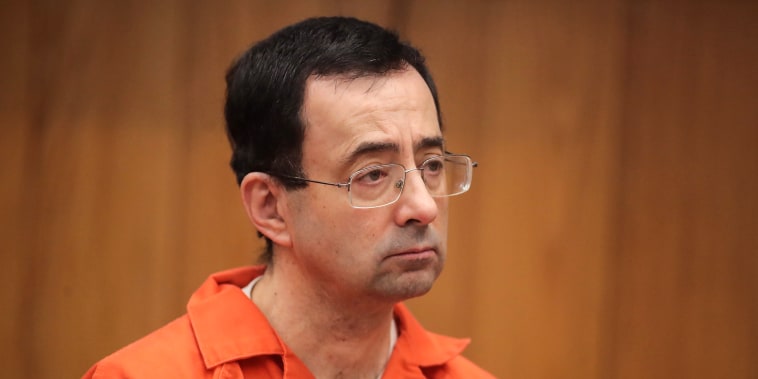Larry Nassar stands as he is sentenced by Judge Janice Cunningham for three counts of criminal sexual assault in Eaton County Circuit Court on Feb. 5, 2018, in Charlotte, Mich.