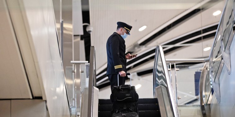 A pilot rides an escalator at the Detroit Metropolitan Wayne County Airport