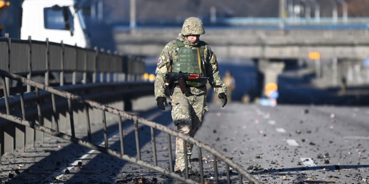 An Ukrainian soldier walks through debris