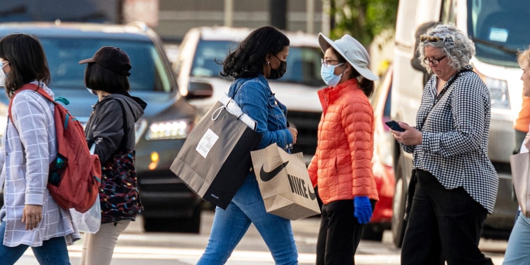 A pedestrian carries shopping bags across Geary Street
