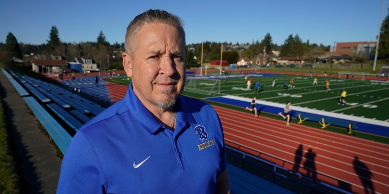 Joe Kennedy, exasistente del entrenador de fútbol de la Bremerton High School en Bremerton, Washington, posa para una foto el 9 de marzo de 2022, en el campo de fútbol de la escuela.