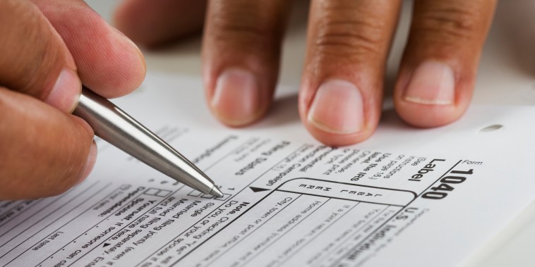 Close up of hands filling in tax form