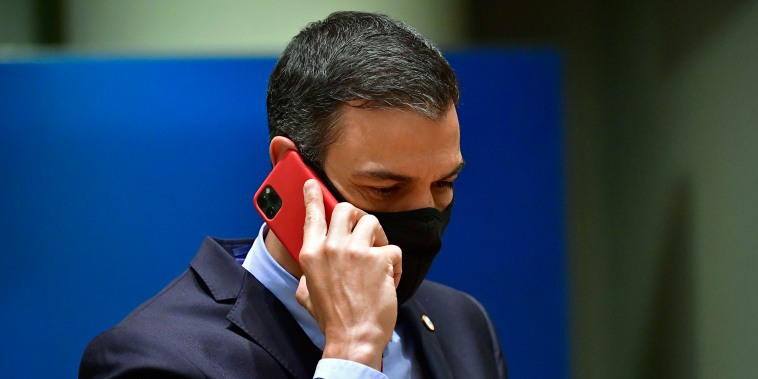 Spain's Prime Minister Pedro Sanchez speaks on his cell phone during a round table meeting at an EU summit in Brussels on July 20, 2020.
