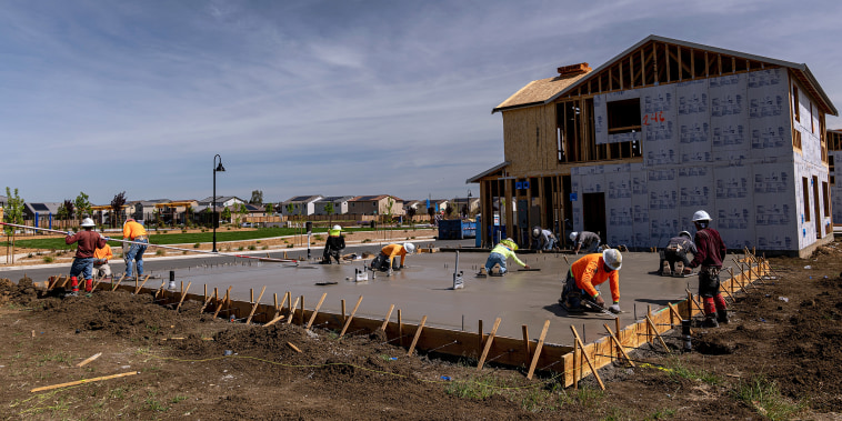 Image: Contractors work on concrete slabs at a housing development in Antioch, Calif., on March 31, 2022.