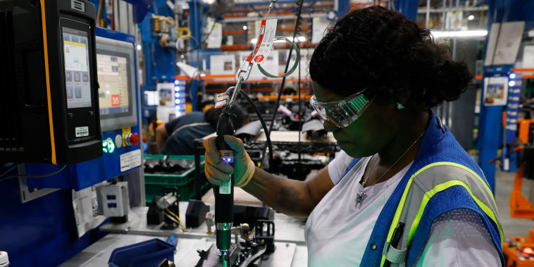 Image: An employee installs lights in an instrument panel at the Dakkota Integrated Systems manufacturing facility in Detroit on May 5, 2022.