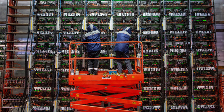 Image: Engineers adjust mining rigs at a cryptocurrency mining farm in Nadvoitsy, Russia, on March 18, 2021.