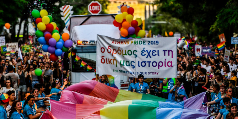 People march with a large rainbow flag as they take part in the Athens Gay Pride Parade in Athens, Greece, on June 8, 2019.