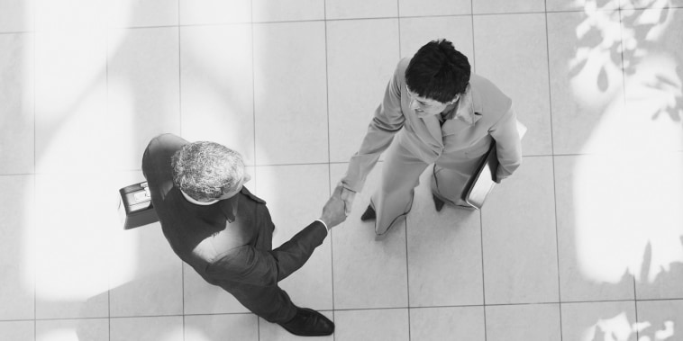 Overhead view of businessman and businesswoman shaking hands