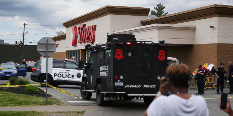 Image: A crowd gathers as law enforcement investigates the scene of a mass shooting at a Tops supermarket in Buffalo, N.Y., on Saturday.