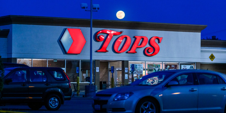 The moon rises behind the Tops Friendly Market on Jefferson Avenue in Buffalo, N.Y., on May 15, 2022.