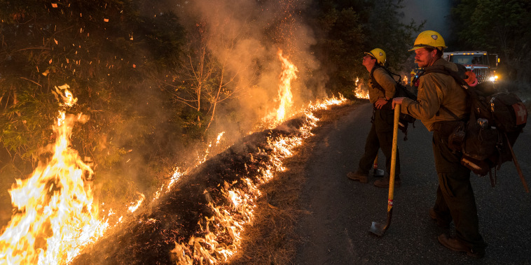Firefighters monitor a controlled burn along Nacimiento-Fergusson Road to help contain the Dolan Fire near Big Sur, Calif., on Sept. 11, 2020.