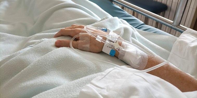 Midsection Of Patient With Iv Drip Relaxing On Hospital Bed