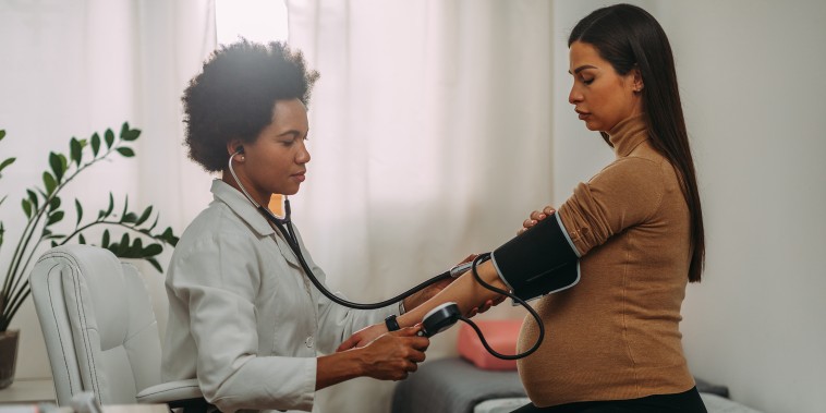 Doctor measuring blood pressure to pregnant woman