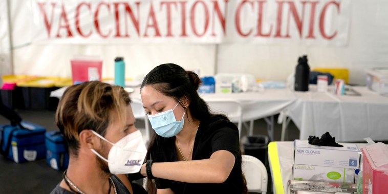 La enfermera Noleen Nobleza administra a Julio Quiñones una vacuna contra el COVID-19 en una clínica instalada en el estacionamiento de CalOptima en Orange, California, el 28 de agosto de 2021.