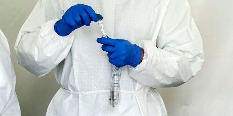 Image:   A Laboratory technician holds a bag with antibody and swab tests tubes for Covid-19 at SOMOS Community Care site in the Washington Heights neighborhood of New York City on May 22, 2020.