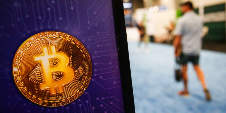 A person walks past a Bitcoin logo at the Bitcoin 2022 Conference on April 8, 2022, in Miami.