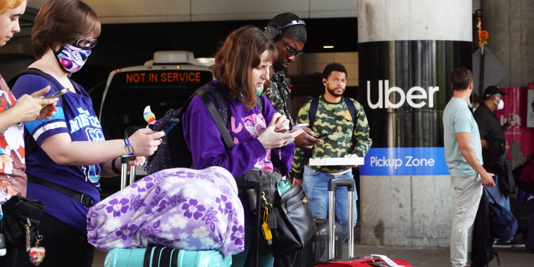 Travelers wait for an Uber